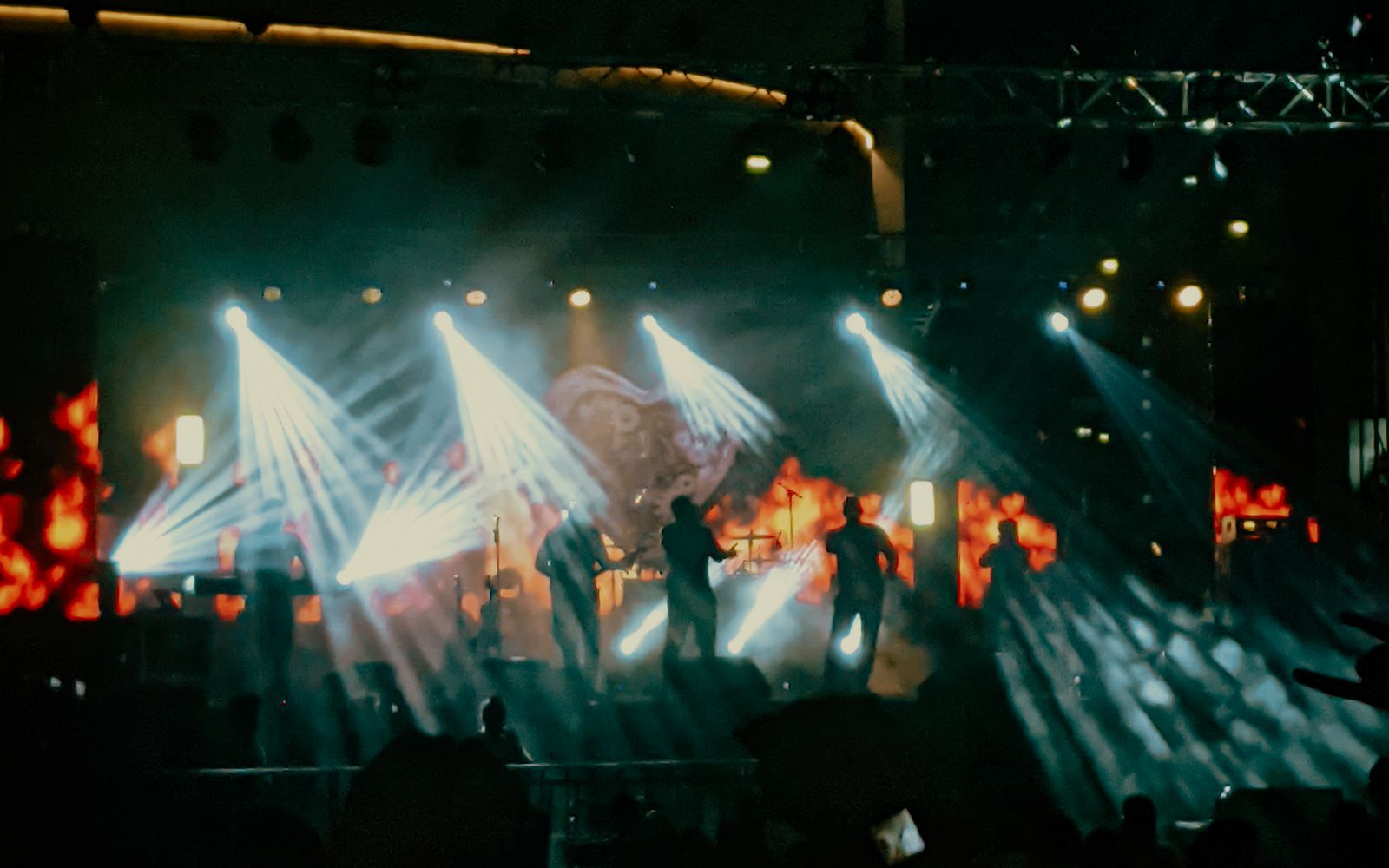 Programmable stage lighting with beam fixtures over a live performance